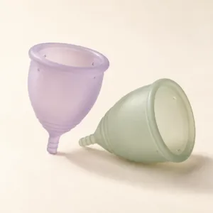 Two reusable menstrual cups in lilac and sage silicone