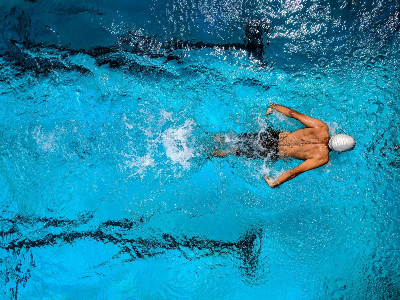 Woman swimming in clear blue ocean water