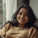 Smiling young Sri Lankan woman relaxing on a sofa in a Colombo apartment
